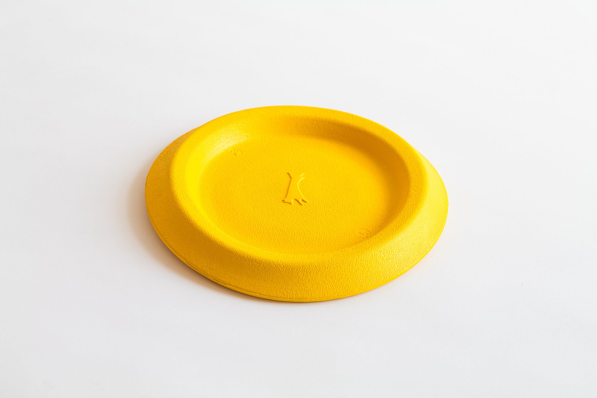 hundefrisbee in gelb von schräg oben